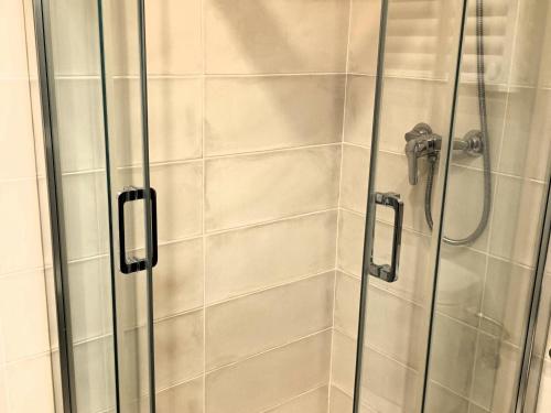 cabina de ducha con puerta de cristal y cabezal de ducha en Apartamento Roses, 1 dormitorio, 4 personas - ES-258-61, en Roses
