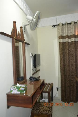 a room with a desk with a mirror and a lamp at Al-Minar Hotel in Zanzibar City