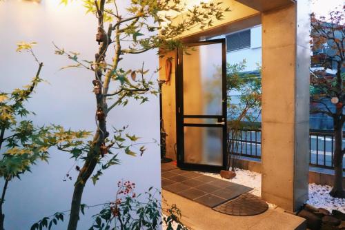 an open door to a house with a tree at naramachiの宿 自助入住 请看邮件 in Nara
