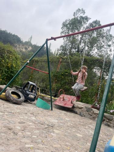 a little girl on a swing in a playground at CASARMONIA in Peumos