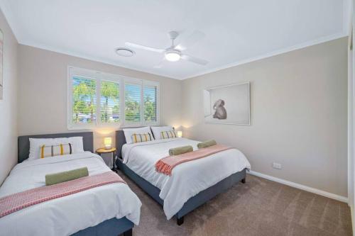 a bedroom with two beds and two windows at Flynns Beach Resort - Port Macquarie beachside apartment - Flynn114 in Port Macquarie