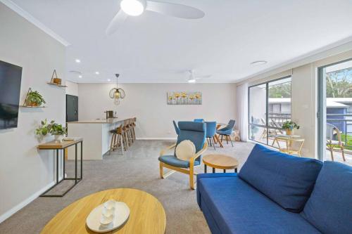 a living room with a blue couch and a kitchen at Flynns Beach Resort - Port Macquarie beachside apartment - Flynn114 in Port Macquarie