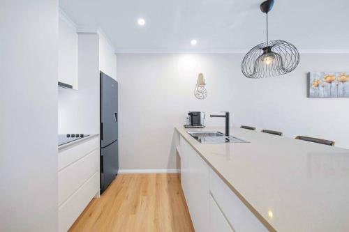 a kitchen with white counters and a black refrigerator at Flynns Beach Resort - Port Macquarie beachside apartment - Flynn114 in Port Macquarie