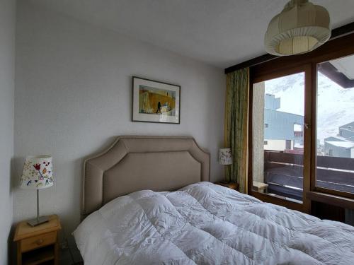 une chambre avec un lit blanc et une fenêtre dans l'établissement Appartement Tignes 5 pers, 2 pièces, proche pistes - FR-1-449-191, à Tignes