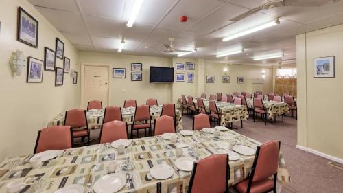 a conference room with tables and chairs and a tv at Tumut Farrington motel in Tumut