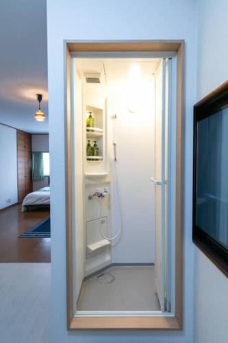 a bathroom with a shower and a tv in a room at Osaka190sqm specious private house max21ppl in Osaka