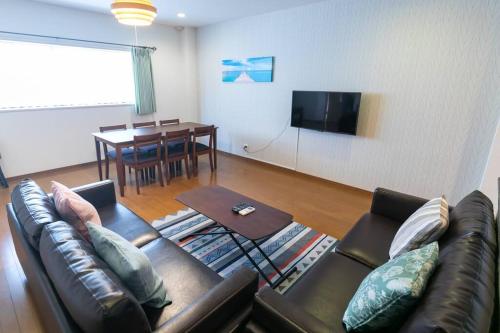 a living room with a couch and a table at Osaka190sqm specious private house max21ppl in Osaka