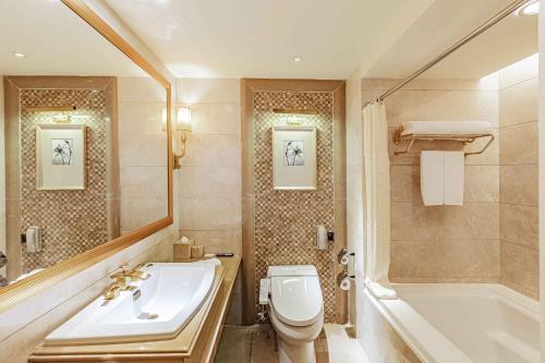 a bathroom with a sink and a toilet and a tub at Grand Bay Hotel Zhuhai in Zhuhai