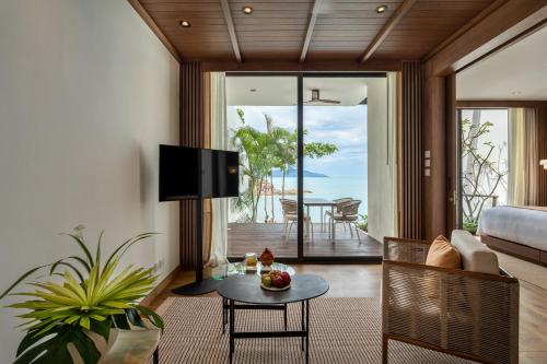 a living room with a couch and a table at Cape Fahn Hotel - Private Islands Samui in Choeng Mon Beach