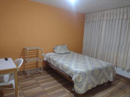 ein Schlafzimmer mit einem Bett, einem Tisch und einem Stuhl in der Unterkunft Lejos de Casa II 