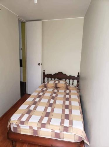 ein Schlafzimmer mit einem großen Bett mit einer karierten Matratze in der Unterkunft Lejos de Casa II 