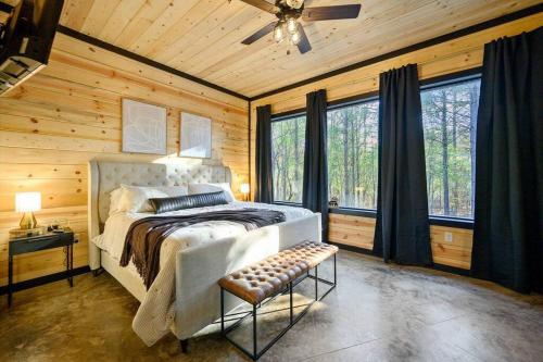a bedroom with a bed in a room with wooden walls at Escape to Hochatown/Broken Bow, Oklahoma Sleeps 10 in Mount Herman