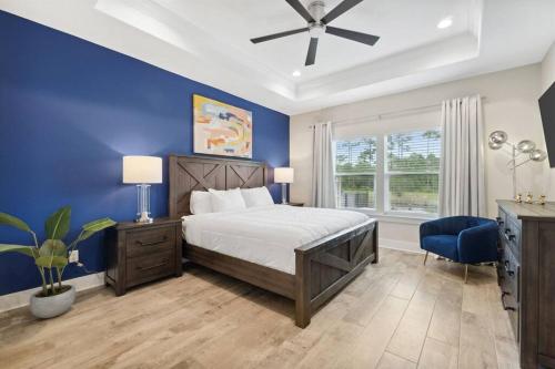 1 dormitorio con cama y pared azul en Laguna Beach House with a Game Room, en Panama City Beach