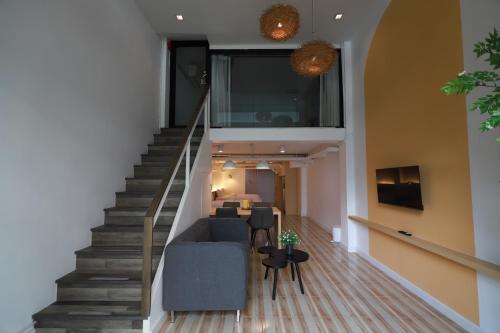 a stairway with a blue couch and a living room at Sovereign Group Hotel at Pratunam in Bangkok