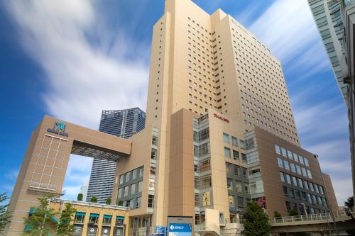 a tall building in front of some buildings at Yokohama Sakuragicho Washington Hotel in Yokohama