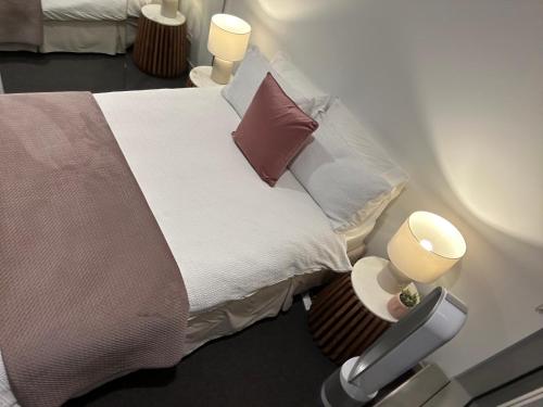 a bedroom with a bed with pillows and two lamps at Rise to the top! in Melbourne