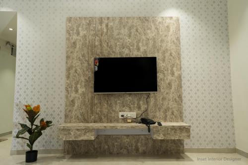 a living room with a tv on a wall at Hotel Mountain View in Nashik