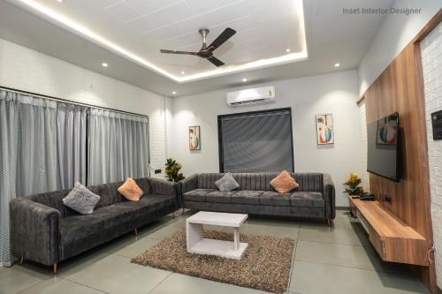 a living room with two couches and a tv at Hotel Mountain View in Nashik