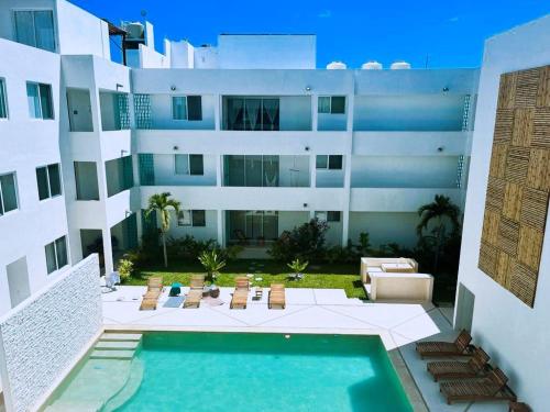 希克蘇魯伯的住宿－Chicxulub Puerto Beach Penthouse，享有带游泳池的大楼的外部景致