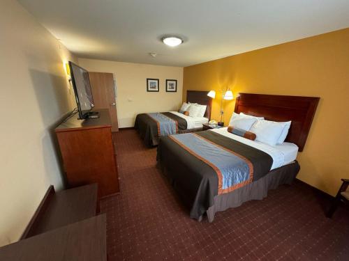 a hotel room with two beds and a flat screen tv at Americas Best Value Inn Saint Robert/Fort Leonard Wood in Saint Robert