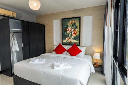 a bedroom with a large white bed with red pillows at The Lucky Beach Ao Nang in Ao Nang Beach