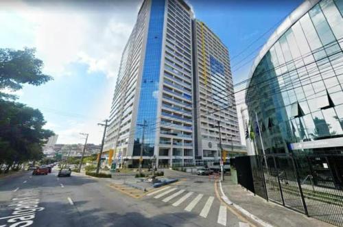 a city street with a tall glass building and a road at Terraço Harmony Flats GRU in Guarulhos