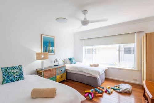 a bedroom with two beds and a window at Bimbajong Yamba - oceanstays in Yamba