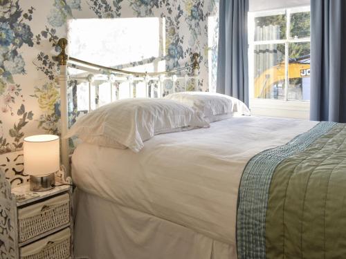 um quarto com uma cama e uma janela em Hunters Cottage - Uk44956 em Pooley Bridge