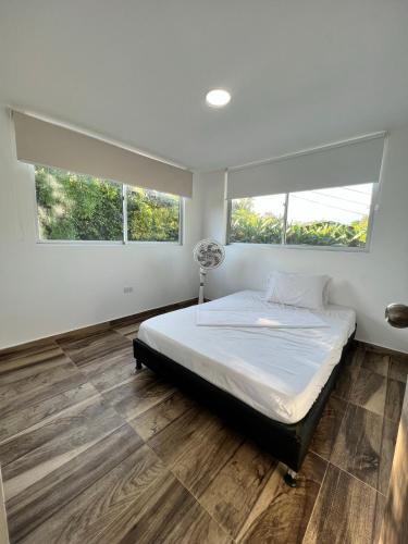 a bedroom with a bed and two windows at poblado canela in Melgar