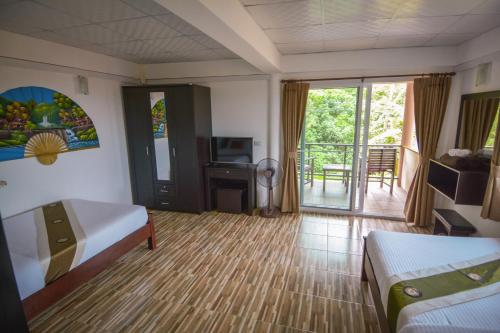 a hotel room with a bed and a balcony at Lanta New House in Ko Lanta