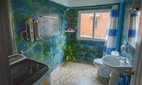 a blue bathroom with a toilet and a sink at Lanta New House in Ko Lanta