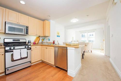 a kitchen with wooden cabinets and a stove top oven at Luxury condo near Irvine Business & UCI Hospital in Irvine