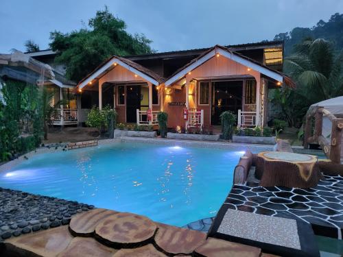 a swimming pool in front of a house at TAMARA GUEST HOUSE in Tioman Island