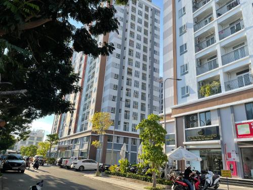 een stadsstraat met een hoog gebouw met auto's bij Mayhome Phan Rang - 2BR City view - 3km to beach in Kinh Dinh
