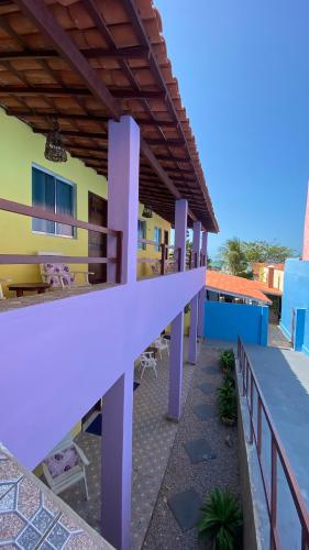a building with a balcony with purple pillars at Pousada Familiar Beberibe in Beberibe