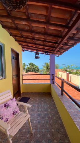 a porch with a chair and a balcony at Pousada Familiar Beberibe in Beberibe