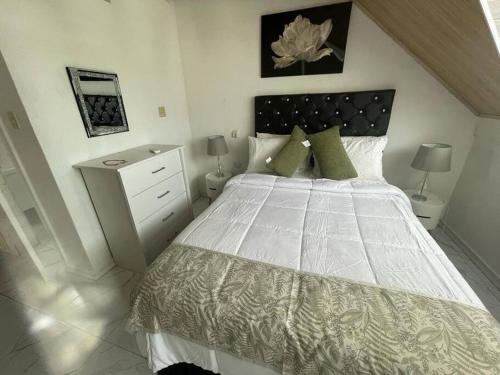 ein Schlafzimmer mit einem großen weißen Bett mit grünen Kissen in der Unterkunft Real Luxe Getaway-Club Caribbean in Salem