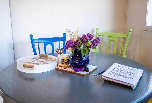 a table with a vase of purple flowers on it at Honey Cottage in Ettrick in Millers Flat