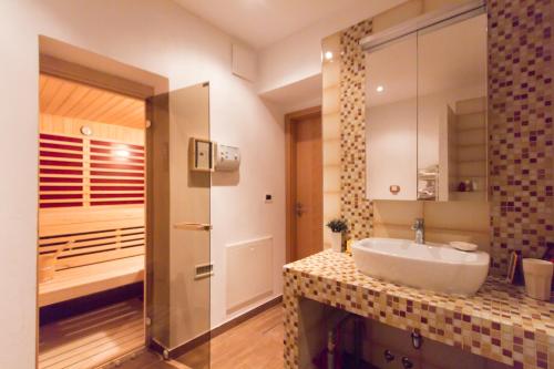 La salle de bains est pourvue d'un lavabo blanc et d'une douche. dans l'établissement Apartment Dezo Istria, à Izola