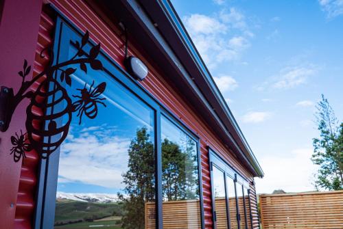 a window on the side of a building with a view at Honey Cottage in Ettrick in Millers Flat