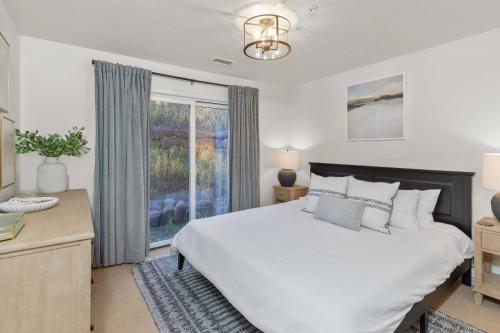 sypialnia z dużym białym łóżkiem i oknem w obiekcie The Outlaw w mieście Telluride