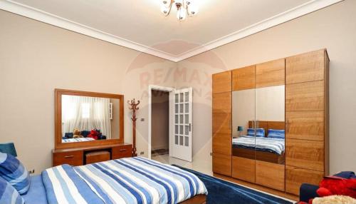 a bedroom with a bed and a dresser and a mirror at خان العطلات in King Mariout