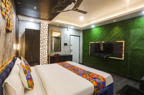 a bedroom with a bed and a flat screen tv at FabExpress Greenstar Inn - Bhubaneswar Airport in Bhubaneshwar