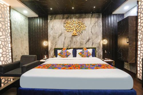 um quarto com uma grande cama branca e uma cadeira em FabHotel Greenstar Inn em Bhubaneshwar