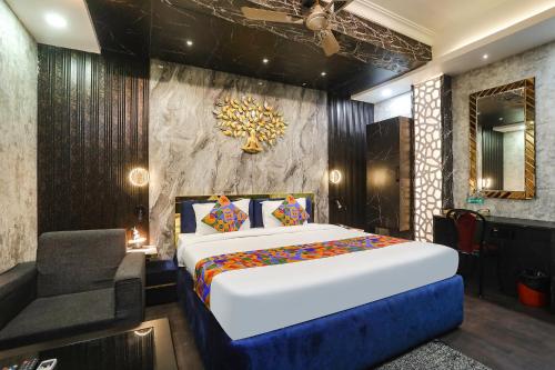 um quarto com uma cama grande e uma cadeira em FabHotel Greenstar Inn em Bhubaneshwar