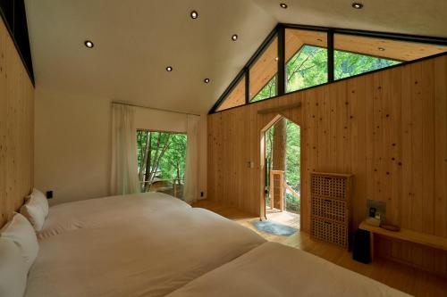 um quarto com uma cama grande e uma janela grande em 自然人村 em Akiruno