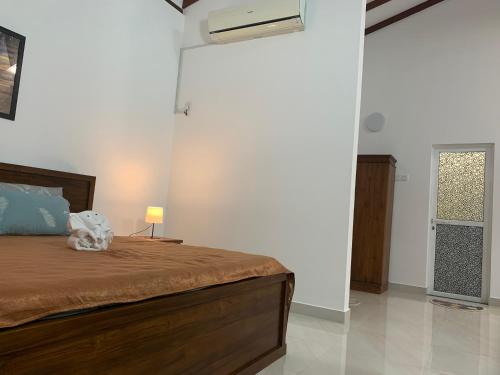 a bedroom with a bed and a lamp on a table at Wasa Villa in Kalutara