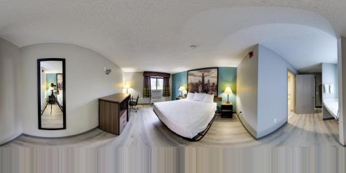 a bedroom with a bed and two mirrors at Super 8 by Wyndham Rockford I-90 Casino District in Rockford