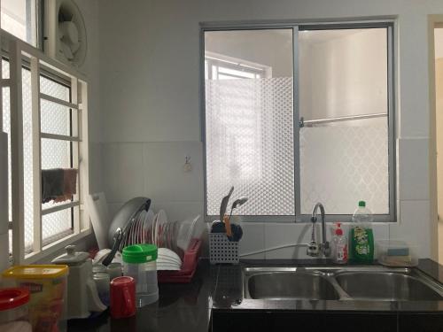 a kitchen with a sink and a window at ABSYAR HOMESTAY SELASIH in Putrajaya