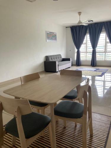 a living room with a wooden table and chairs at ABSYAR HOMESTAY SELASIH in Putrajaya